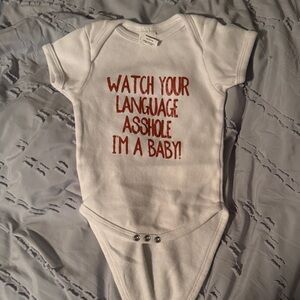 White Baby Onesie with burnt orange Text